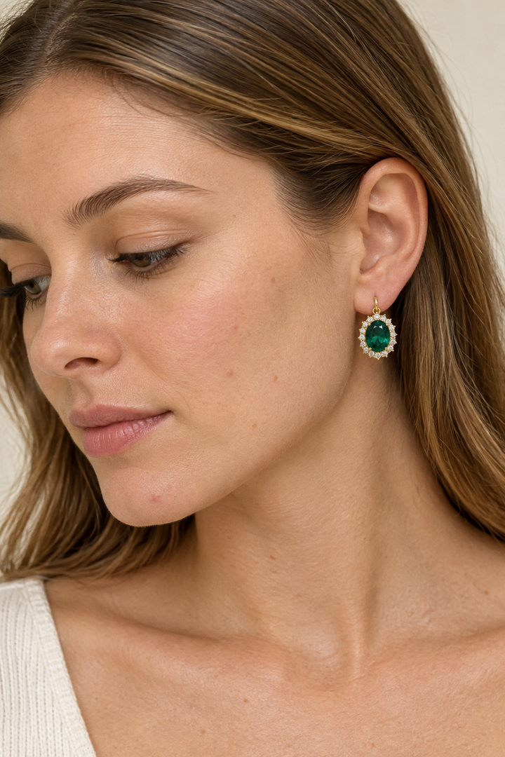 Model wearing an emerald halo earring, top-down view